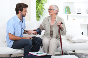 Young man taking the blood pressure of an older lady