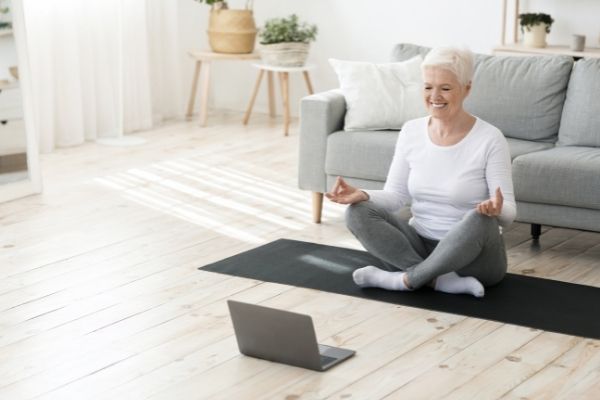 Alt tag: A woman practices core exercises for seniors in her home.