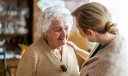 An in-home care representative visiting a client with dementia to assess the potential need for more in-home care.