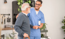 An in-home caregiver assisting a senior on a walk.