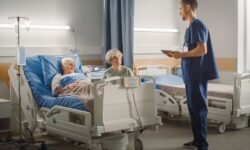 A doctor discussing in-home after-surgery care with an elderly man who just had a knee replacement while his wife listens.