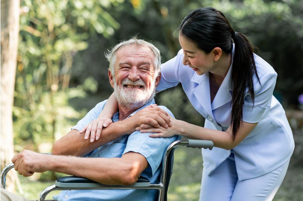 An elderly man getting assistance from his aide that he pays for using insurance that covers in-home care.