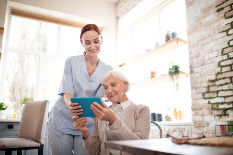 Caregiver and senior video chatting with family